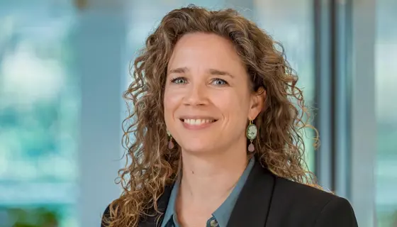 Portrait of Astrid Boumans, Director, Europe, inside a glass office with plants